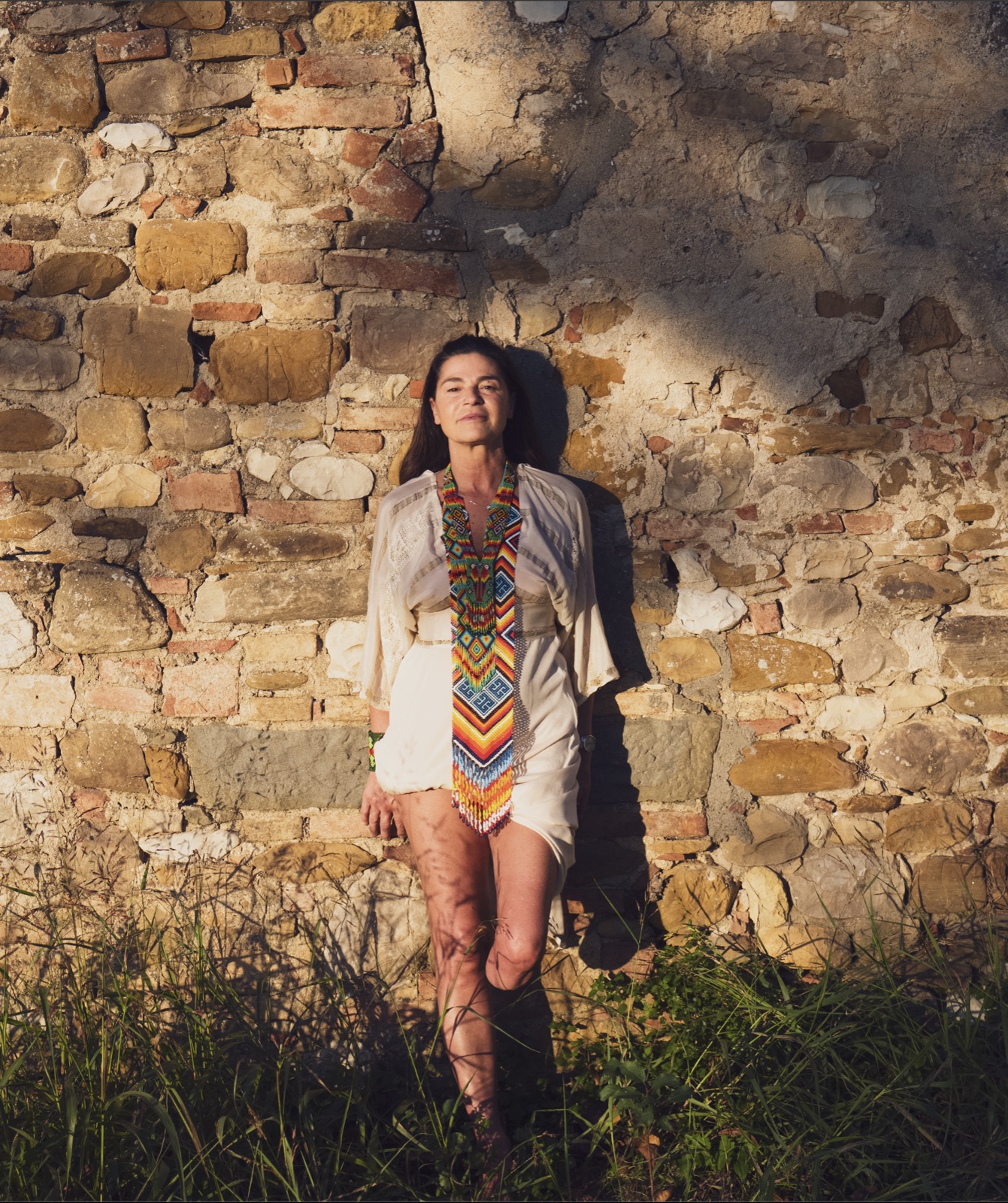 Michèle against a Tuscan stone wall at golden hour